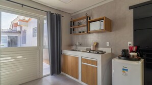 Eine moderne Küche mit integriertem Mikrowellenherd, einer Kaffeemaschine und einem Kühlschrank.