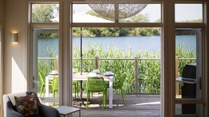 Eine Terrasse mit Tisch und Stühlen mit Blick auf einen See.