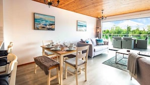 A modern living room with a dining area, wooden flooring, and a balcony with outdoor furniture. - Spring Lake 43, Jesse-Belle (P) - Lakeside Holiday Lodge, Watersports, Sleeps 6 (South Cerney)