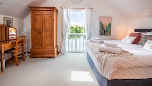 A bedroom with a bed, a wooden wardrobe, a desk with a chair, and a window with a view of greenery. - Spring Lake 43, Jesse-Belle (P) - Lakeside Holiday Lodge, Watersports, Sleeps 6 (South Cerney)
