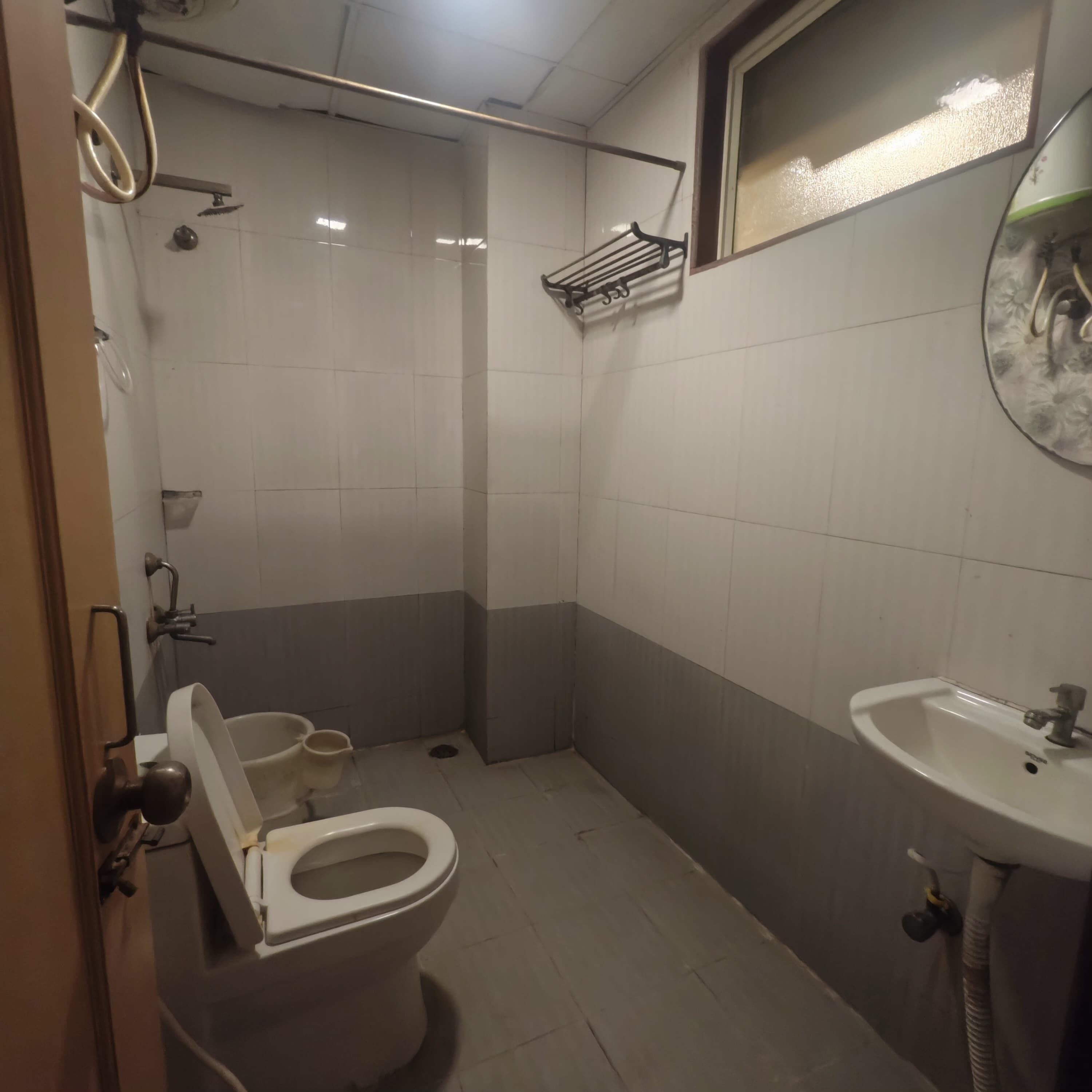 Une petite salle de bain avec des toilettes, un lavabo et une douche.