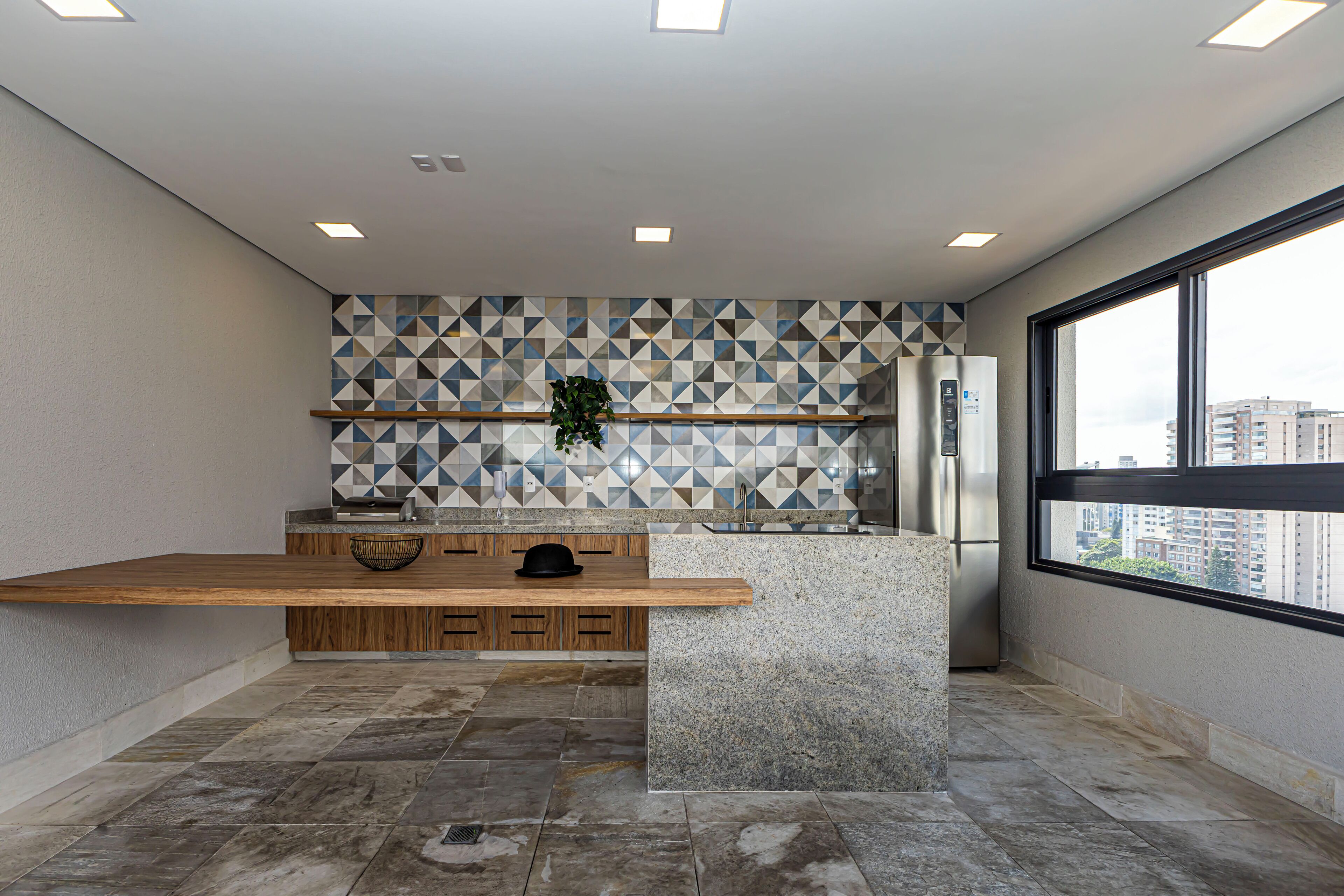 A modern kitchen with a wooden countertop, a built-in sink, and a backsplash with geometric tiles.