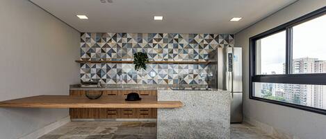 A modern kitchen with a wooden countertop, a built-in sink, and a backsplash with geometric tiles.
