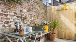 A picnic setup with a table, a bench, and a potted plant. - Tell-Tale Cottage, Deal (Deal)
