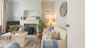 A cozy living room with a fireplace, comfortable seating, and artwork on the walls. - Michaelmas Cottage, Broadstairs (Broadstairs)