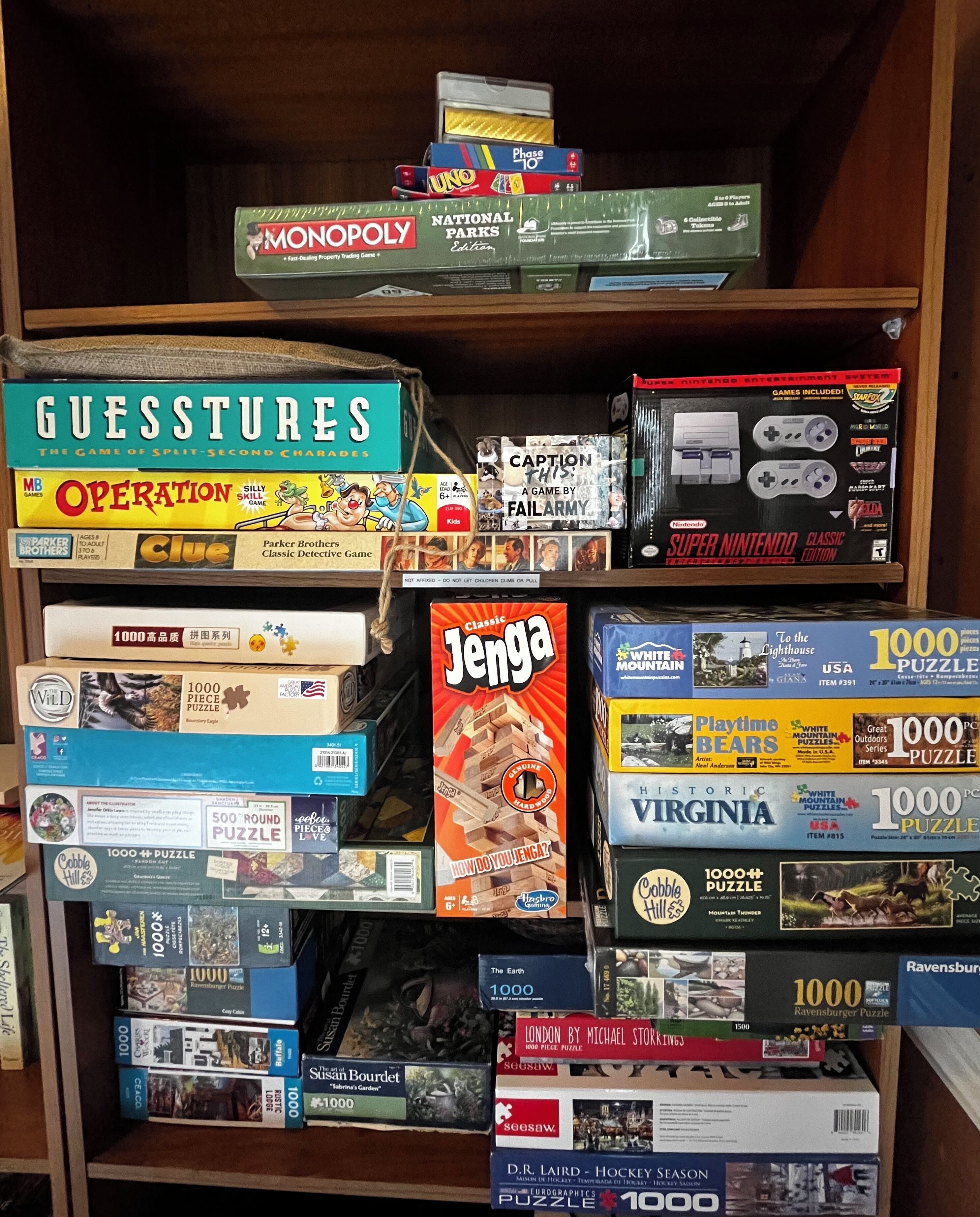A bookshelf filled with various board games and puzzles.