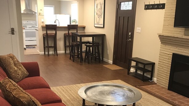 Un salon avec un canapé rouge, une table basse ronde et une cheminée.