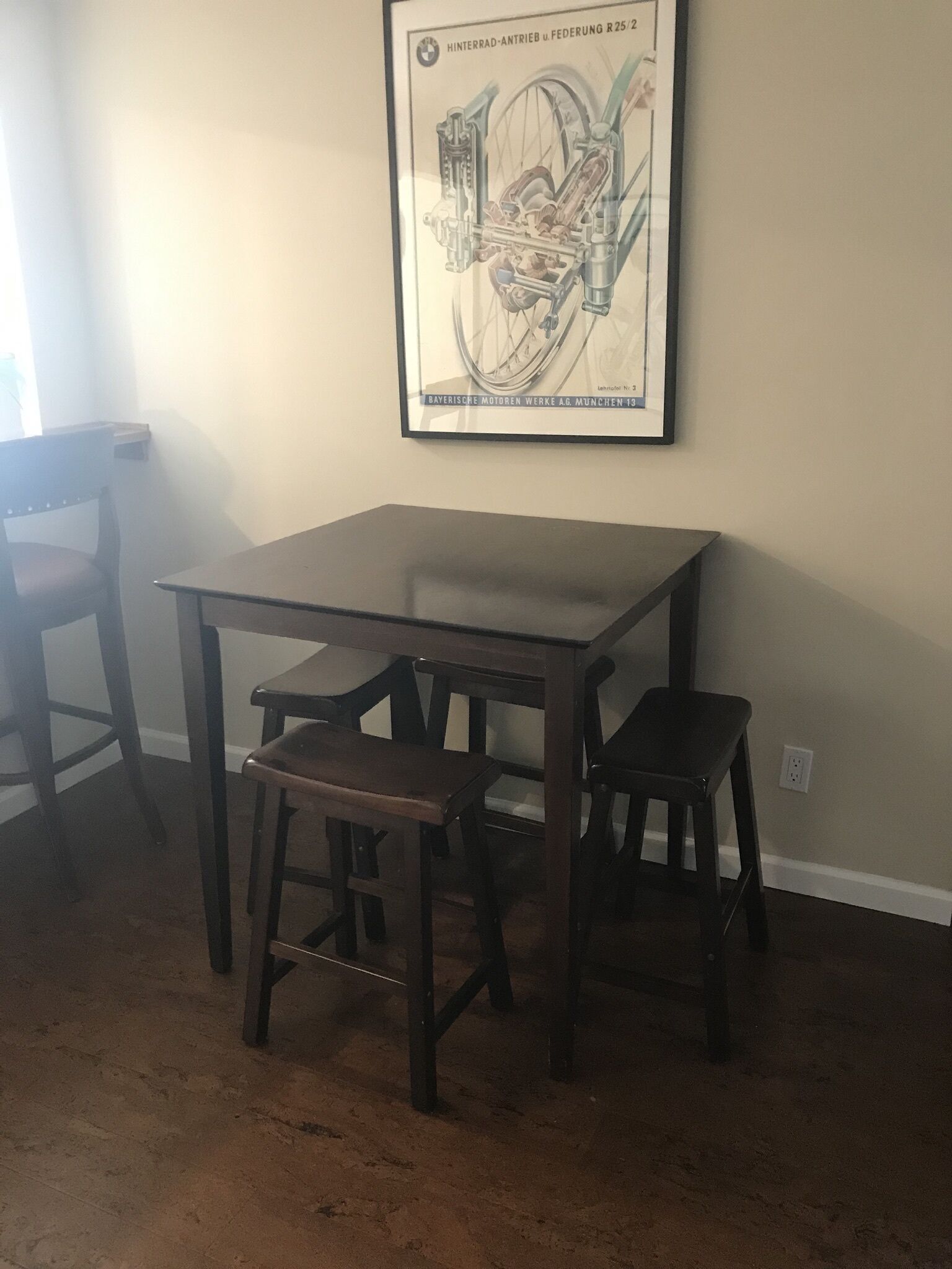 Ein Essbereich mit Tisch und zwei Stühlen, einem gerahmten Bild an der Wand und einem Teppichboden.