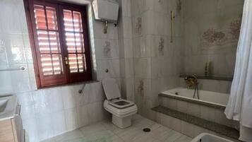 A bathroom with a toilet, sink, bathtub, and shower.