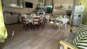 Un amplio salón con una mesa de comedor, sillas y un sofá.