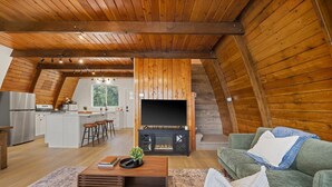 Een knus loft-achtig woongedeelte met een keuken, een eethoek en een open haard.