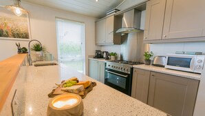 A modern kitchen with granite countertops, stainless steel appliances, and a central island with a candle.