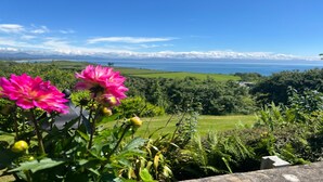 A garden with vibrant flowers and a view of the sea.