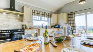 Une cuisine moderne avec un coin repas, comprenant une cuisinière, un four et une table à manger dressée pour le repas.