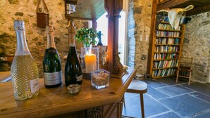 Una zona de bar con botellas de vino, una vela y una estantería.