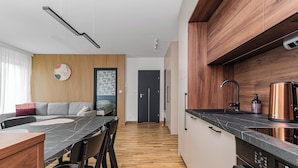 A modern kitchen with a built-in oven, a coffee maker, and a stainless steel sink. - Perła Mierzei by Grand Apartments (Sztutowo)