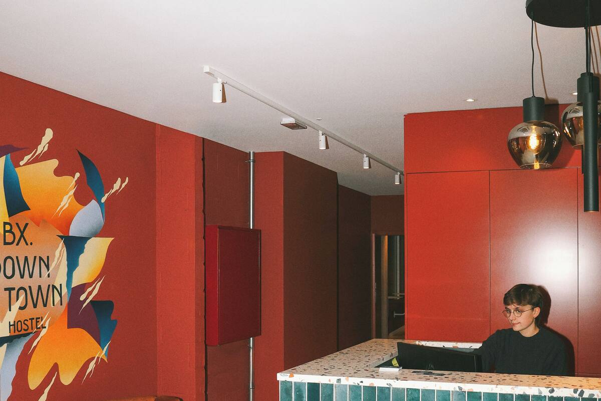 Ein Empfangsbereich mit roter Wand, blau gefliestem Empfangstresen und einem braunen Sessel.
