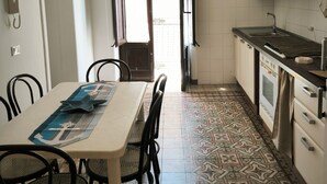 A kitchen with a dining table, chairs, a sink, and a stove. - Trinity House (Castellammare del Golfo)