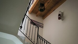 A staircase with a wooden ceiling and a metal railing. - Trinity House (Castellammare del Golfo)