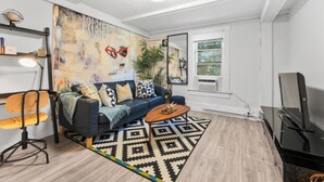 A modern living room with a blue sofa, wooden coffee table, and a patterned rug.