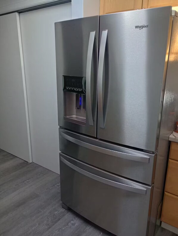 Ett kylskåp i rostfritt stål från Whirlpool med vattendispenser och en fryslåda.