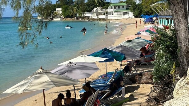 A beach with clear blue water, lounge chairs, umbrellas, and a few people. - Palm Retreat luxury 4 bedroom maisonette with pool, just 400m from Mullins Beach (Saint peter)