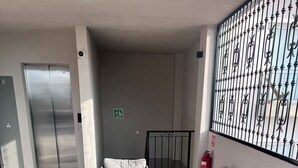 A lobby with a seating area, a fire extinguisher, and a security camera. - New studio Apt. in the coveted Zona Romantica with roof top pool (Puerto Vallarta)
