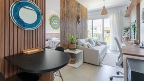 Un salon moderne avec un grand miroir rond, un canapé, une table à manger et une grande fenêtre.