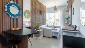 Un salon moderne avec un canapé, une table à manger et un grand miroir.