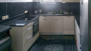 Una cocina con estufa, fregadero y armarios.