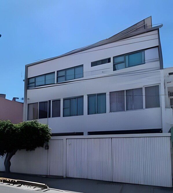 A modern two-story building with large windows and a flat roof.