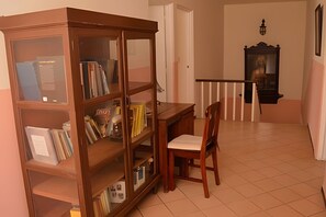 A room with a wooden bookcase, a desk, and a chair.