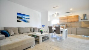 A modern living room with a sofa, coffee table, and dining area. - Amazing apartment in Novigrad with swimming pool (Novigrad)