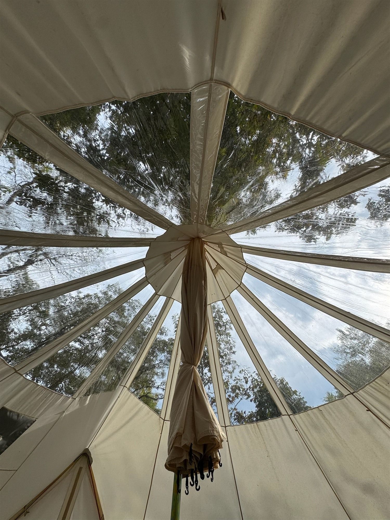 Uma tenda com um mastro central e vários painéis de tecido que se estendem para fora.