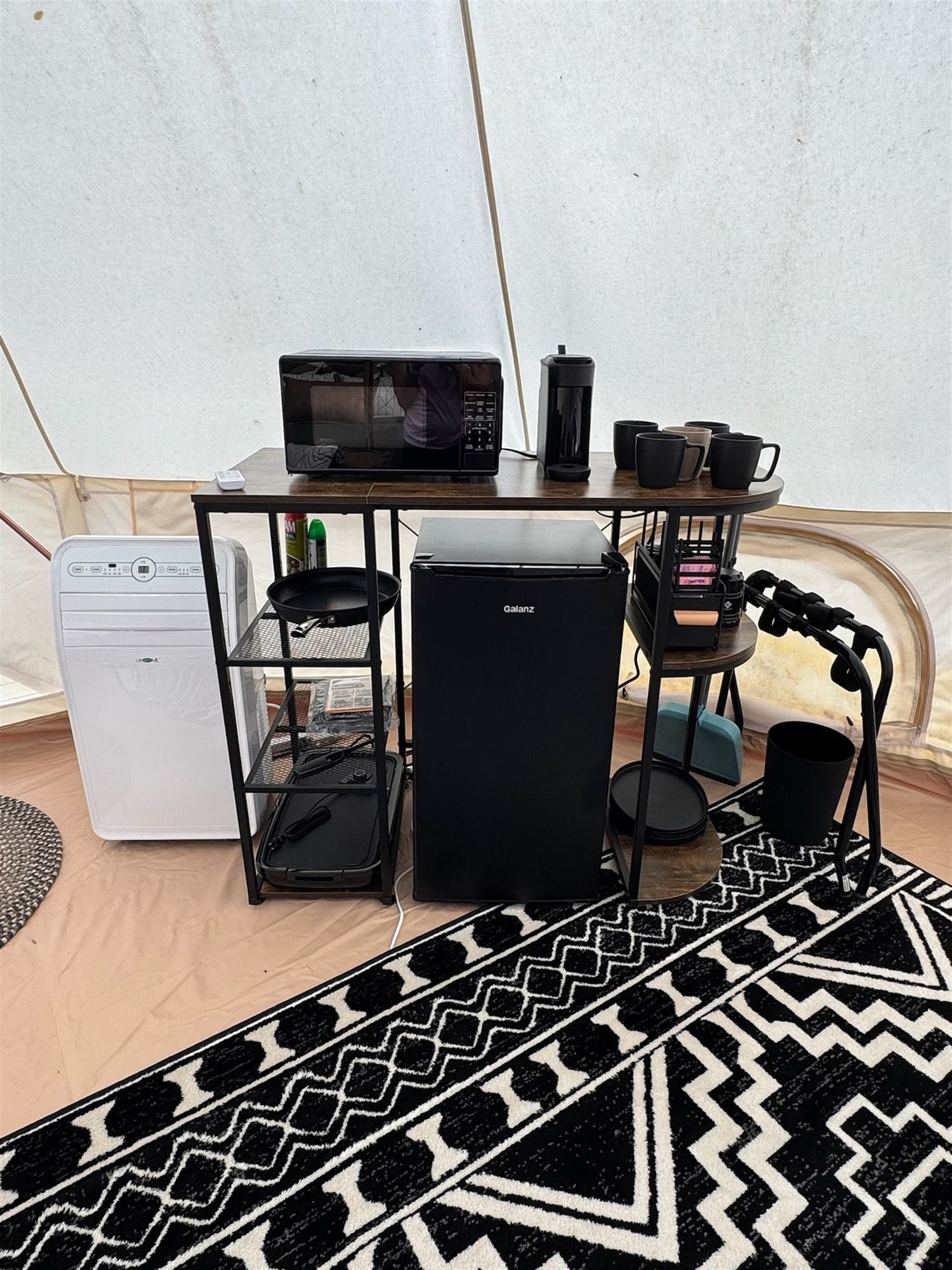 A compact kitchenette with a microwave, coffee maker, and small refrigerator.