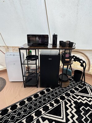 A compact kitchenette with a microwave, coffee maker, and small refrigerator.