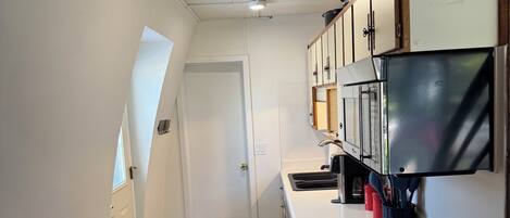 A kitchen with a stove, microwave, and cabinets.