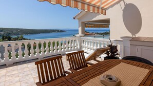 A balcony with a view of the sea, a table with chairs, and a potted plant. - Pet friendly apartment in Kampor with WiFi (Kampor)