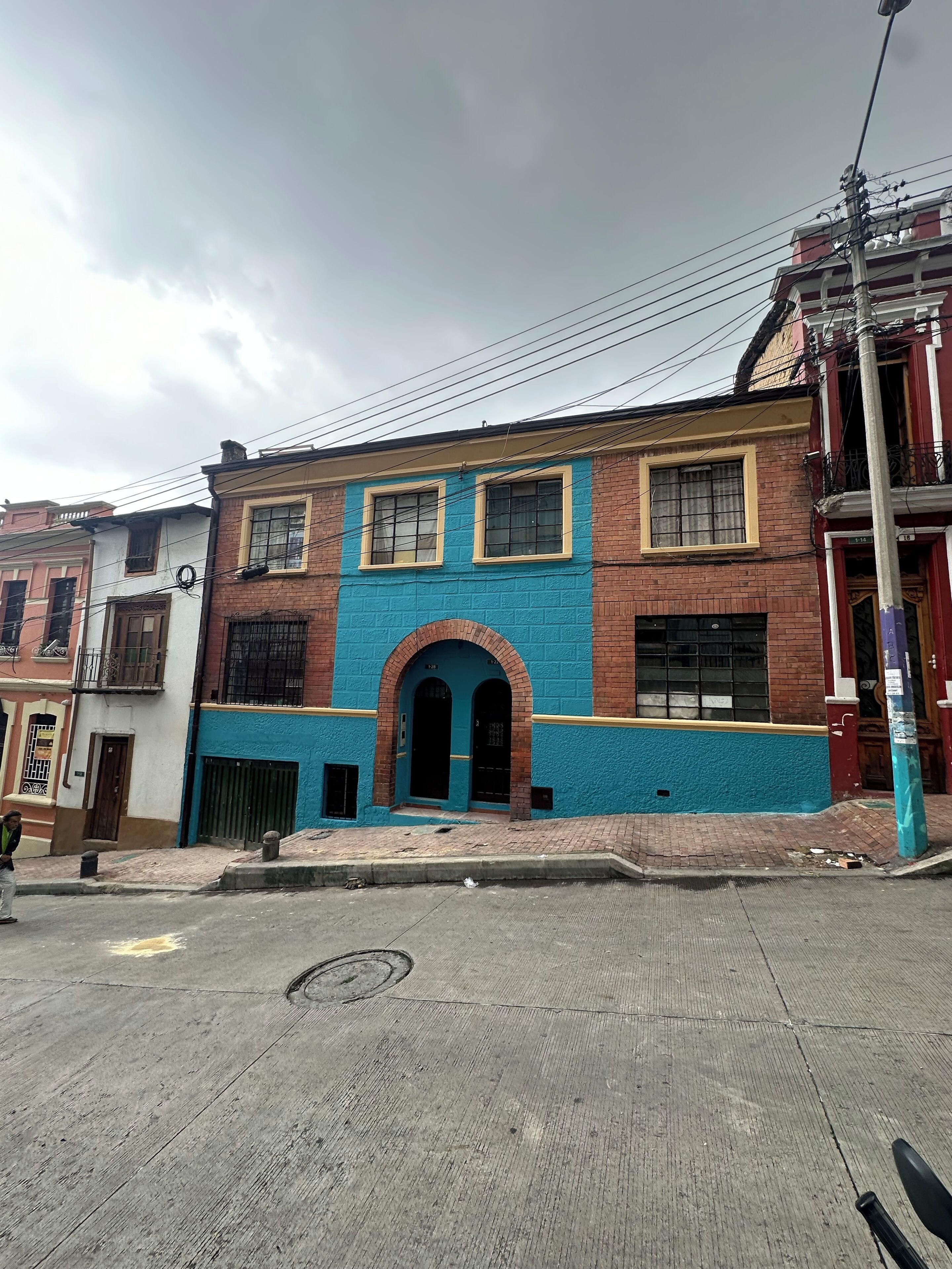A two-story building with a blue facade and a red brick base.