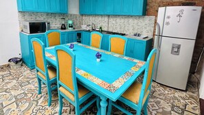 A kitchen with turquoise cabinets, a white refrigerator, and a patterned tile floor. - AQUI ME QUEDO here I stay (Bogota)