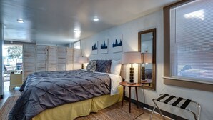 A bedroom with a large bed, bedside lamps, a mirror, and artwork on the wall. - Dock&Volleyball! Near Downtown- Orange Oasis (Savannah)