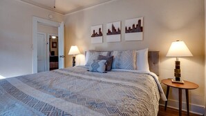 A bedroom with a large bed, two bedside lamps, and three wall-mounted pictures. - Dock&Volleyball! Near Downtown - Flamingo Flat (Savannah)