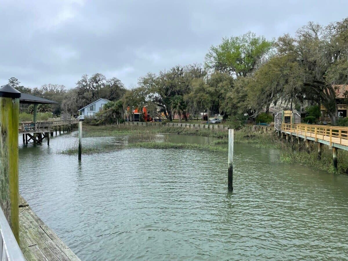 Una zona ribereña con pasarelas de madera y un muelle que se adentra en el agua.