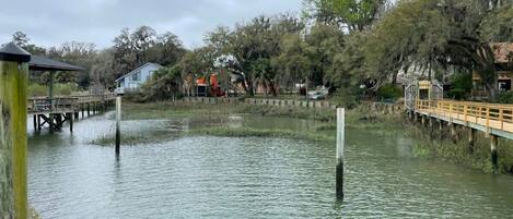 Una zona ribereña con pasarelas de madera y un muelle que se adentra en el agua.