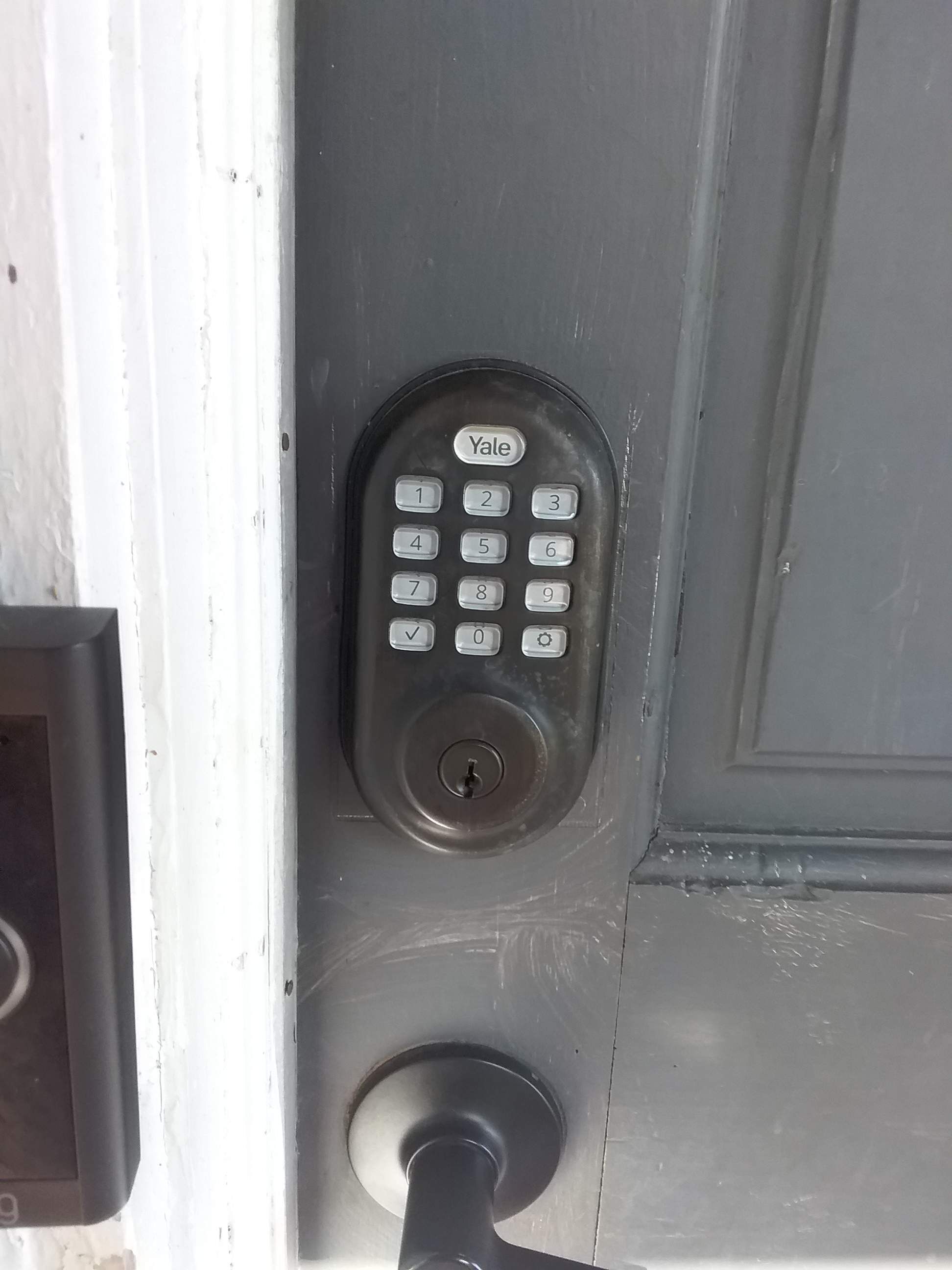A Yale door lock with a keyhole and a numeric keypad.