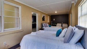 Un dormitorio con dos camas, un armario y una pequeña kitchenette.