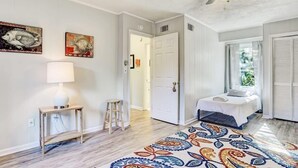 Une chambre à coucher avec un lit, une table de chevet, une lampe, une chaise et un tapis à motifs.