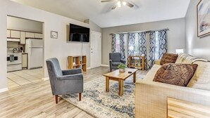 A modern living room with a sofa, armchairs, a coffee table, and a ceiling fan. - Fenced Yard, Patio & BBQ · Historic District Area (Savannah)