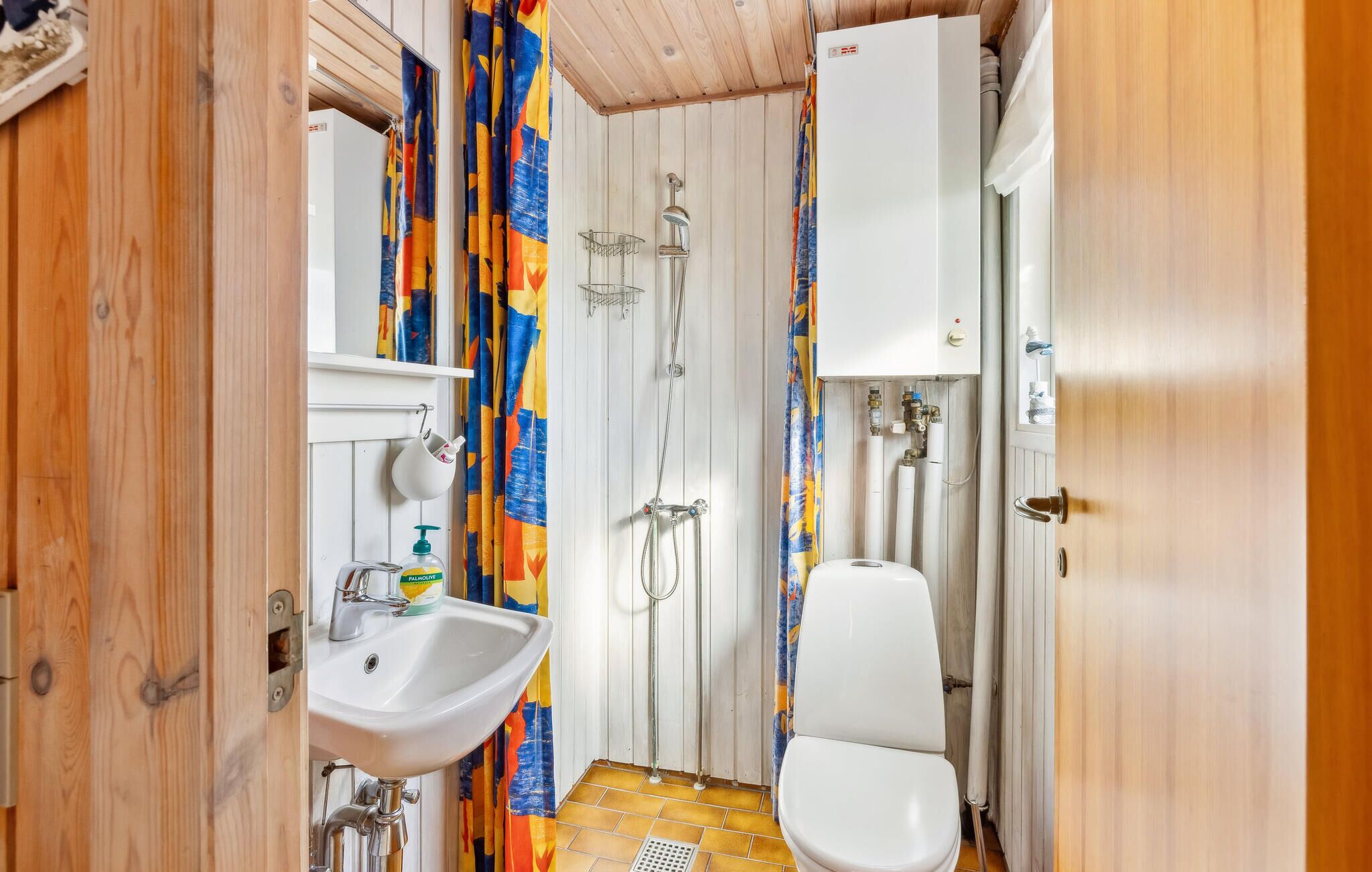 Une petite salle de bain comprenant un lavabo, des toilettes, une douche et un meuble blanc.
