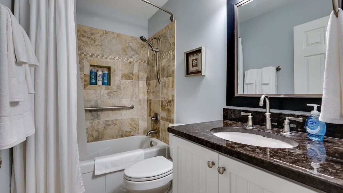 A bathroom with a bathtub, toilet, and sink.
